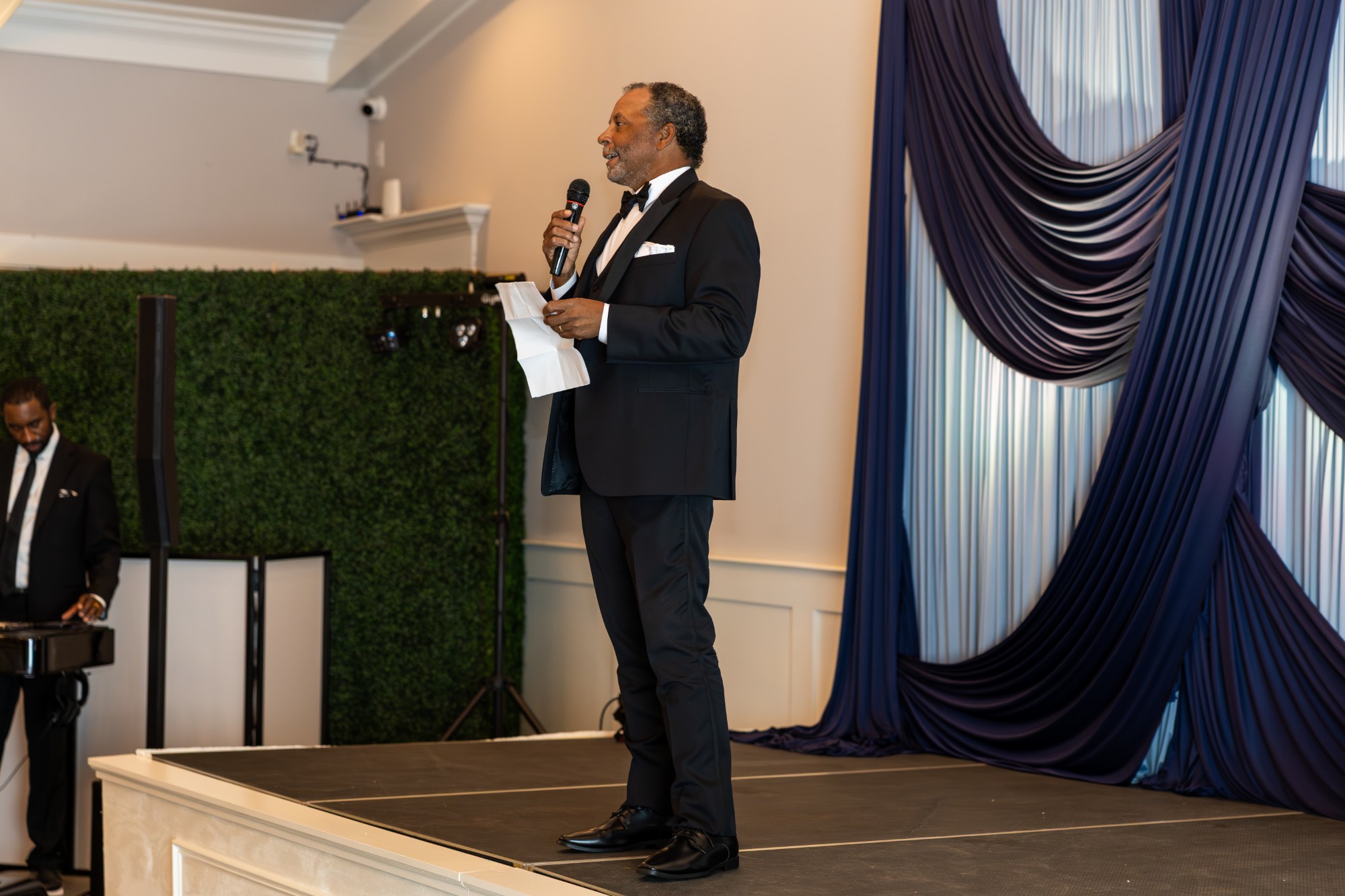 David Jones speaking on stage at a black-tie event